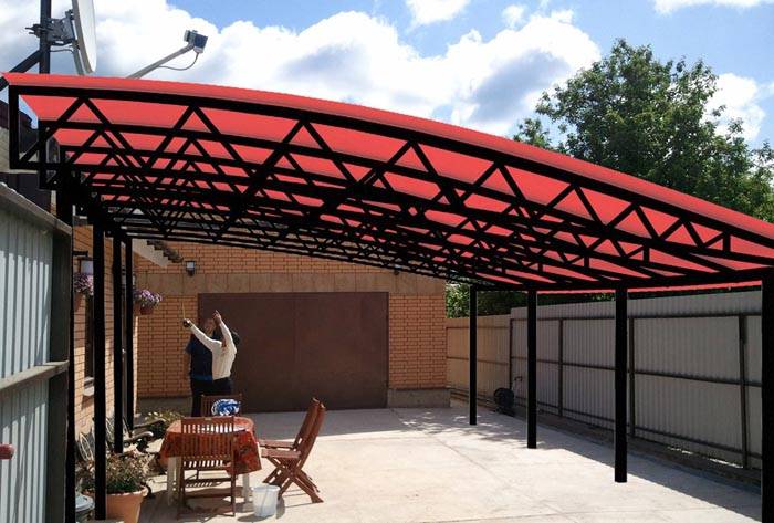 The location of the object between the garage and the house will create a weatherproof space. If the site is large, there will be a place for a recreation area