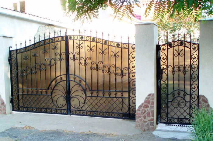 พื้นหลังเบลอเล็กน้อยด้านหลังประตูช่วยขยายพื้นที่ของไซต์และในขณะเดียวกันก็มีแสงแดดส่องเข้ามาซึ่งช่วยให้คุณเก็บสนามหญ้าหรือเตียงดอกไม้ไว้ด้านหลังประตูได้