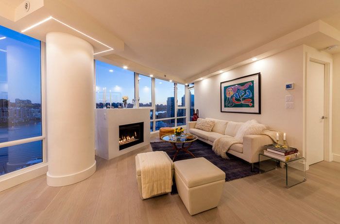 Cette photo du salon montre un exemple de camouflage réussi de la structure de pouvoir dans un appartement. Le changement de forme a transformé un élément fonctionnel en une décoration originale. Coutures soulignant la légèreté