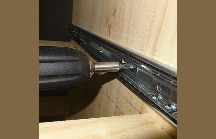 Então você pode montar os guias. A madeira compensada é colocada sob os painéis laterais da gaveta, eles são puxados para fora e as guias são instaladas ao longo de todo o comprimento