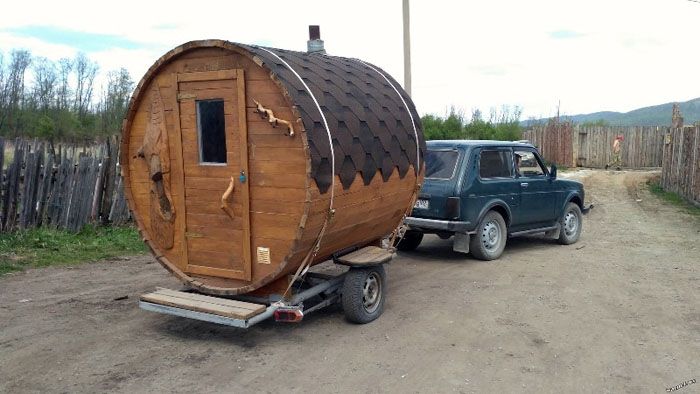 A barrel sauna on wheels, placed on a single-axle car trailer
