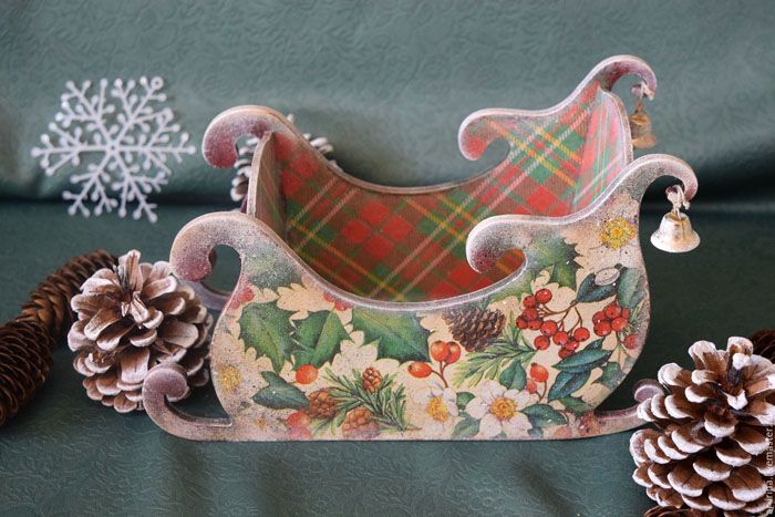 Lengan serbet akan mencari jalan di antara alas meja di atas meja. Mudah untuk membuat kereta luncur seperti itu dengan tangan anda sendiri dari kadbod dan menghiasnya dengan decoupage dari serbet Tahun Baru