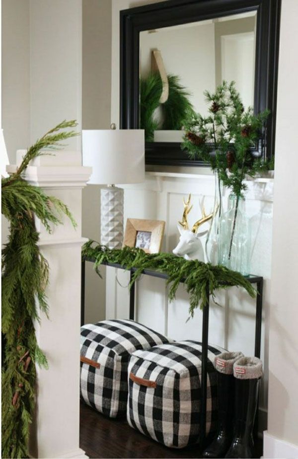 Celor cărora nu le place în mod deosebit dominanța bilelor colorate de Anul Nou le va plăcea decorarea simplă a holului cu coroane de conifere și ghirlande