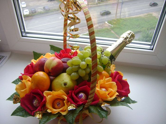 First, champagne is placed on the bottom, then a row of fruits. Sweets wrapped in corrugated paper in the form of flower petals are allowed along the edge