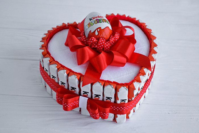 The box is assembled according to the principle of New Year's candy hours. Flat-shaped candies are glued along the edge of the box in the form of a heart, sweets are placed inside, the outdoor decor can either contain a lot of candies or not