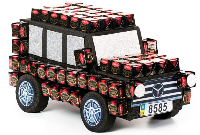 The machine can be assembled from tea boxes and add a few cardboard parts. Both hot glue and double-sided tape are used to attach the sweet.