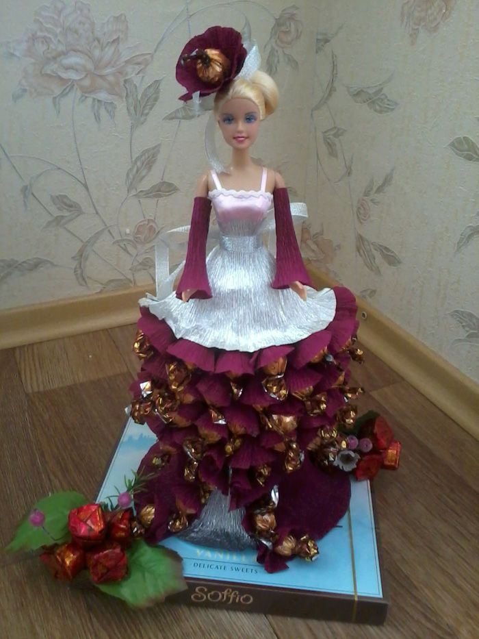 We wrap the sweets in corrugated paper and glue it on a cardboard base, which we fix around the doll like a skirt. This skirt will not let the young lady fall