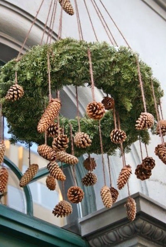 Ако сгънете клоните на иглите в пръстен и окачите съцветията към тях, ще получите импровизиран полилей. За да може тя да участва в осветяването, такъв интересен венец е увит с LED гирлянд.