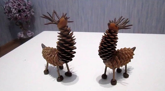 От пластилин и дълги шишарки ще се получат красиви елени. Закачете ги около кръста, тъй като главата ще бъде твърде крехка. За да предотвратите висянето на елените и счупването на рогата им върху борови клони, по-добре е да ги прикрепите към дървото с тел