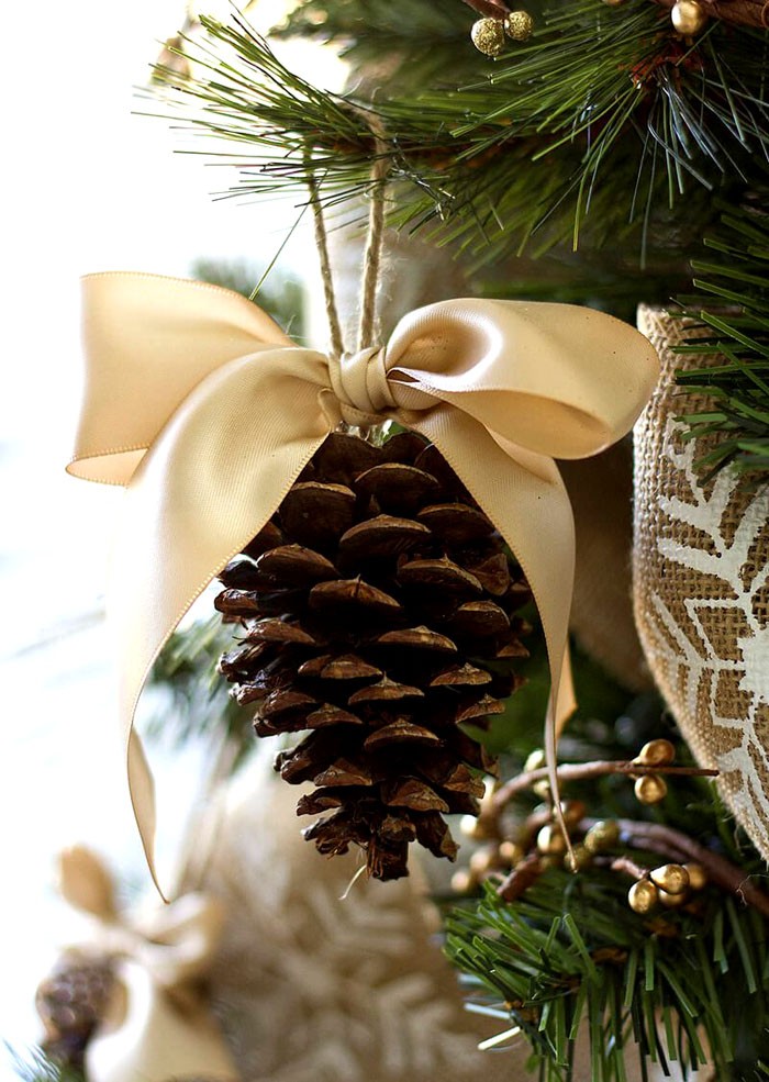 След като завиете винт в конус, остава само да го завържете към дървото, без да забравяте да украсите с готов лък, сгънат от лента