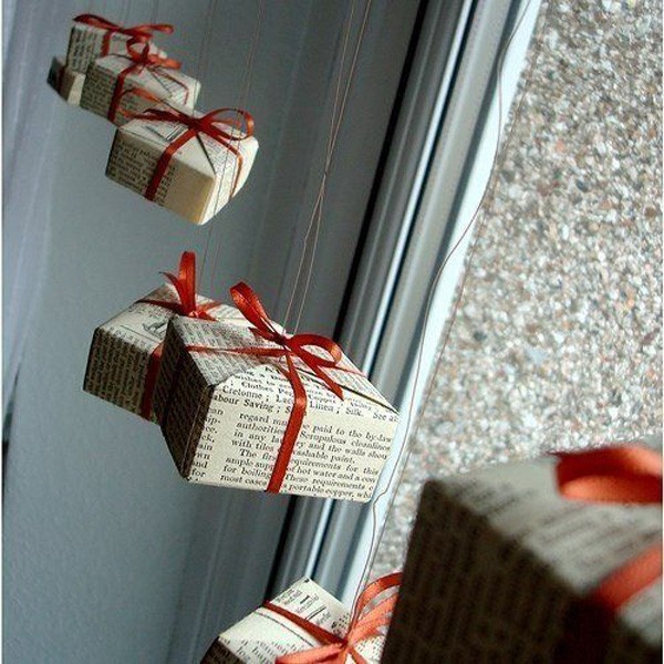 We use unnecessary boxes or make them ourselves. If you wrap them in regular newspaper and decorate with a satin ribbon with a bow, you can hang such fake gifts on the window.