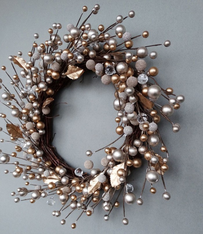 A wreath can be made of anything, branches also become a non-standard solution, especially if you place exquisite silver and gold-colored Christmas decorations at their ends
