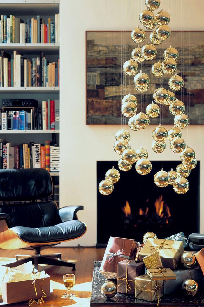 A stylized Christmas tree made of balls can hang from the ceiling. For suspension, use thread or fishing line. Each ball is placed at a different distance, together creating the image of a fir. You can hang the composition on a suitable embroidery hoop by rewinding them with fishing line, like a cobweb. The hoop itself can be easily attached to the ceiling with self-adhesive hooks. Only with a stretch ceiling, this number is unlikely to pass harmlessly to the surface