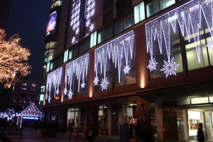 Leichte Girlanden können verschiedene Formen haben: Maschen, Fransen, Muster, Wasserfall, Regen. Je heller die Fassade und der Eingang zum Laden, desto besser