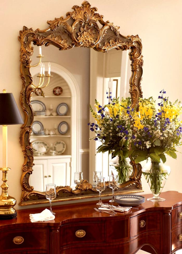 The massive gilded frames of the large mirrors add weight to the space, creating a visual balance between furniture and wall decoration. You can always put fresh flowers in a chic vase on the bedside table near the mirror
