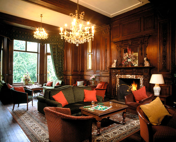 Die Wanddekoration kann mit dekorativen Holzvertäfelungen erfolgen, die eine besondere Atmosphäre rund um den massiven Kamin schaffen