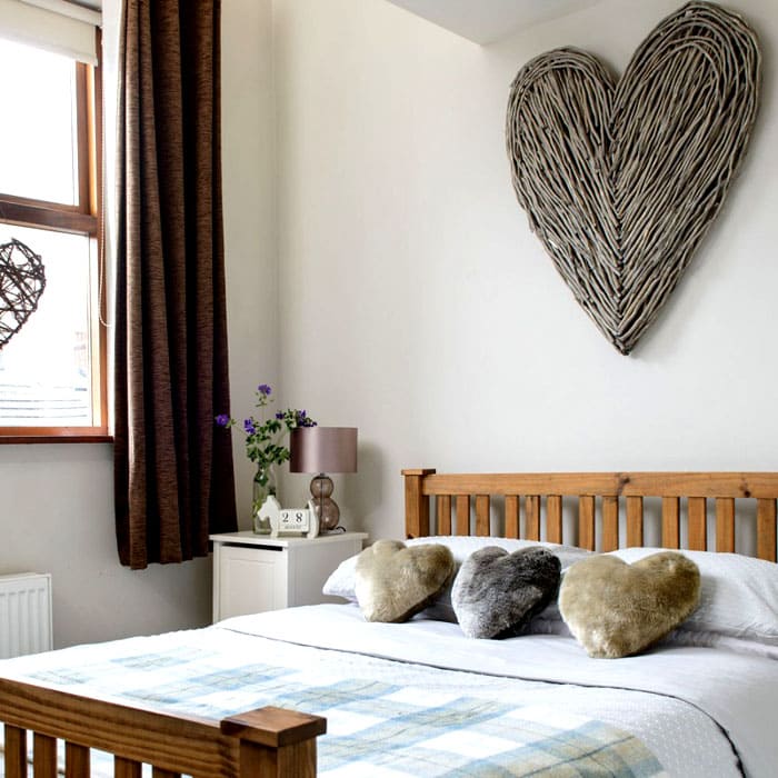 O tema do coração é bom. Você pode fazer um coração na parede com jornais retorcidos, cordas, tecidos, juta