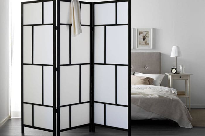 Folding screens with a subtle silhouette effect look intriguing, separating the bedroom from the rest of the apartment