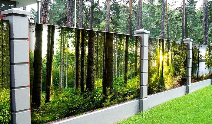 Das schicke Design des Zauns auf einem Gebiet mit hohen Bäumen imitiert die Sichtbarkeit natürlicher Stämme