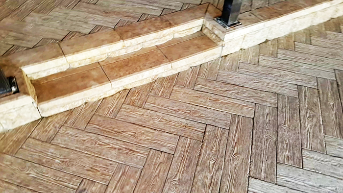 Bei der Verwendung von Keramikverkleidungen, die Holz imitieren, sollte die Fliesenfuge minimal sein und mit einer Fuge gefüllt sein, deren Farbe dem allgemeinen Hintergrund so nahe wie möglich kommt